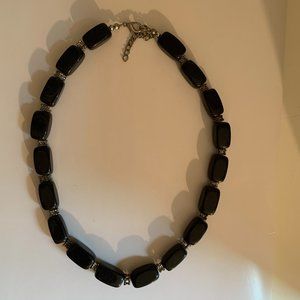 chunky black necklace with intricate silver detail